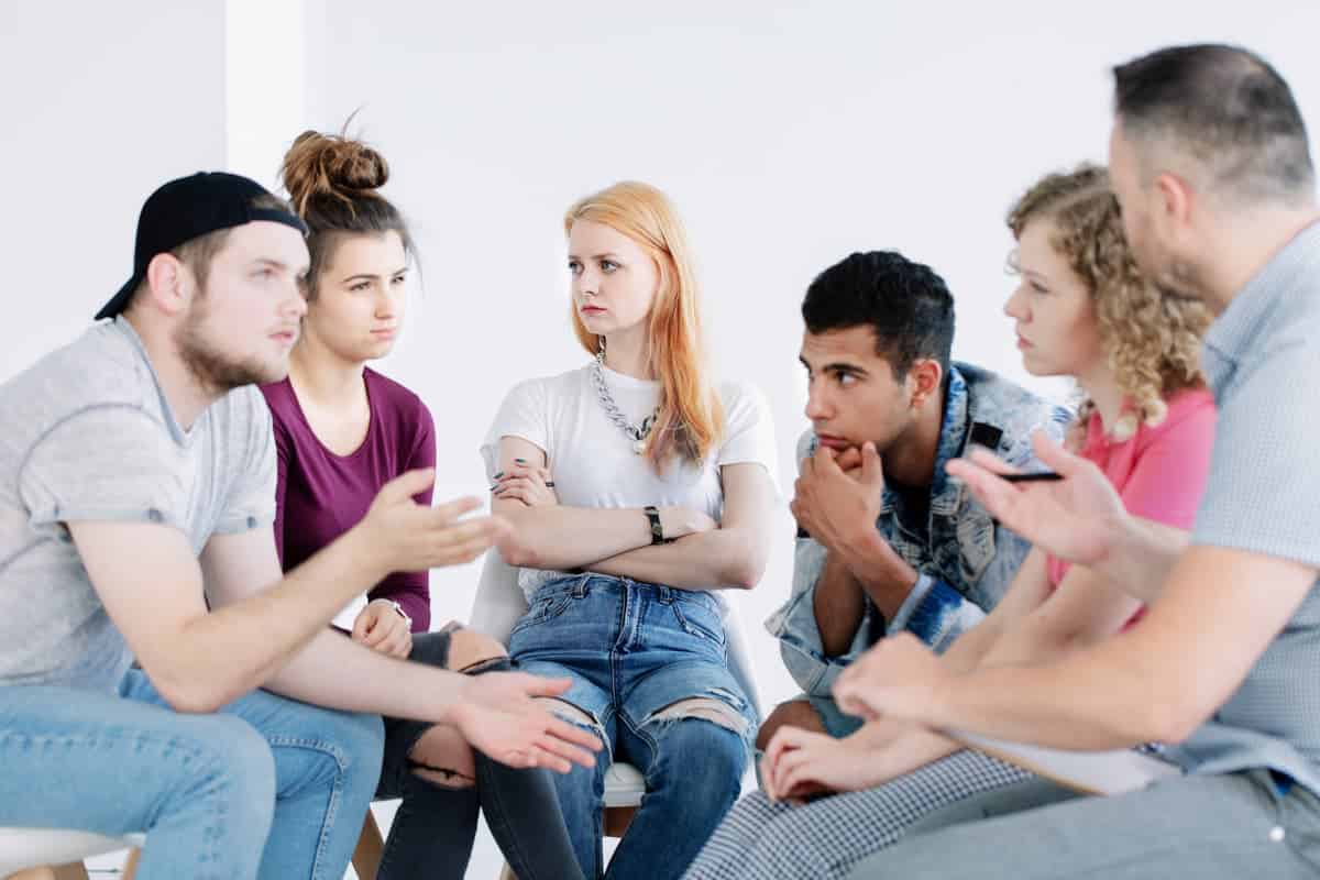 In der Intensiv Wohngruppe für Jugendliche sitzen junge Menschen im Kreis und diskutieren 